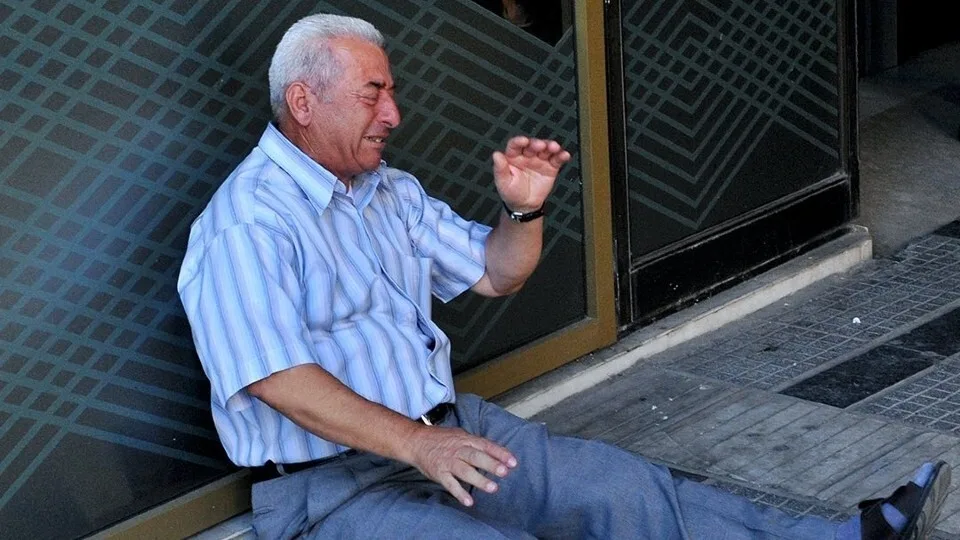 Στις φωτογραφίες της 10ετίας ο Έλληνας συνταξιούχος που κλαίει έξω από τράπεζα